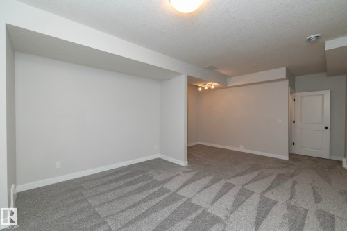 Recessed lighting, patterned carpet flooring, flush mount ceiling light, white interior door with black hardware, and neutral wall tones - 55 Michigan Street, Devon, AB 