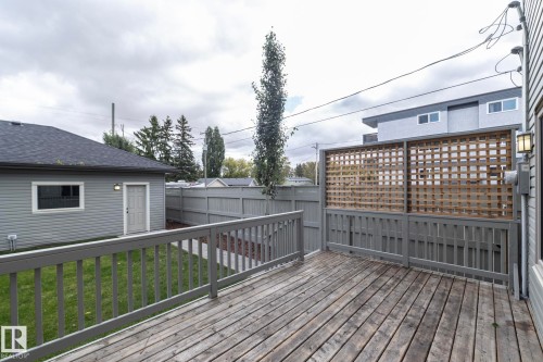 Expansive wooden deck with a privacy lattice screen and a gray painted fence - 55 Michigan Street, Devon, AB 