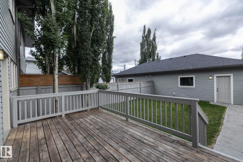 Expansive wood deck with painted railings, surrounded by a wood privacy fence - 55 Michigan Street, Devon, AB 