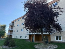 Multi-story building featuring a stucco exterior and multiple balconies with white railings - 