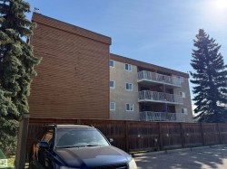 Multi-story building featuring stucco exterior and individual balconies with white railings - 