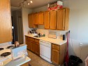 Kitchen featuring wood-finish cabinetry, track lighting, a tile backsplash, and a built-in dishwasher - #414 3611 145 Av Nw, Edmonton, AB 