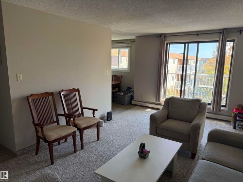 Sliding glass door leading to a balcony, complemented by a large window - #414 3611 145 Av Nw, Edmonton, AB 