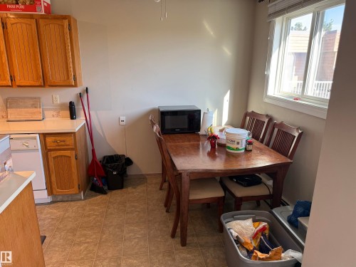 Kitchen featuring wood-finish cabinetry, light-toned countertops, and a tile backsplash - #414 3611 145 Av Nw, Edmonton, AB 
