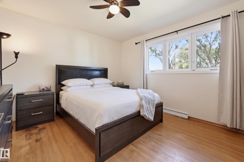 Hardwood flooring and a ceiling fan are complemented by a triple window unit - 13655 122 Avenue Nw, Edmonton, AB 