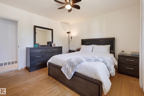 Light wood-finish flooring with a ceiling fan and recessed lighting - 13655 122 Avenue Nw, Edmonton, AB 