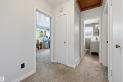 Hallway with light gray walls, white trim, and carpet flooring - 