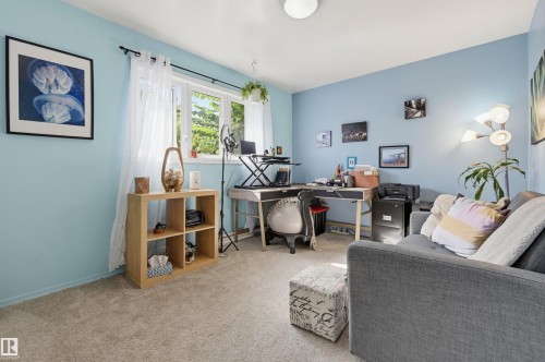 Light-toned carpeting, light blue wall paint, and a window with natural light - 13655 122 Avenue Nw, Edmonton, AB 