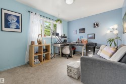 Light-toned carpeting, light blue wall paint, and a window with natural light - 