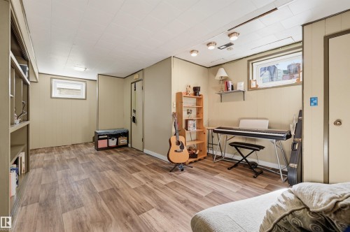 Wood-finish flooring with light-colored paneled walls, a drop ceiling, built-in shelving, and recessed lighting - 13655 122 Avenue Nw, Edmonton, AB 