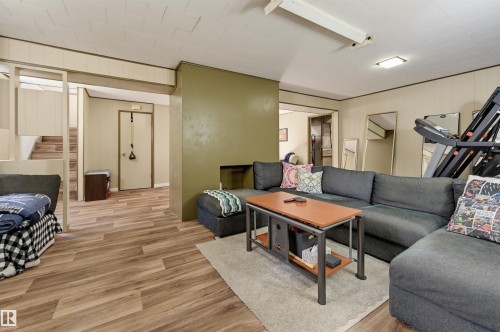 Wood-finish flooring throughout, with a recessed wall feature and paneling - 13655 122 Avenue Nw, Edmonton, AB 