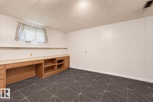 Wall-to-wall carpeting with geometric pattern, extensive built-in cabinetry with desk space, and integrated shelving - 13655 122 Avenue Nw, Edmonton, AB 