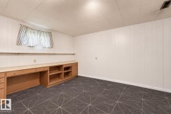 Wall-to-wall carpeting with geometric pattern, extensive built-in cabinetry with desk space, and integrated shelving - 