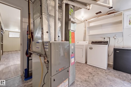 Utility area featuring a washer and dryer, built-in shelving, and a mini-fridge - 13655 122 Avenue Nw, Edmonton, AB 