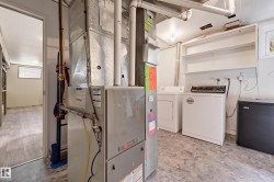 Utility area featuring a washer and dryer, built-in shelving, and a mini-fridge - 