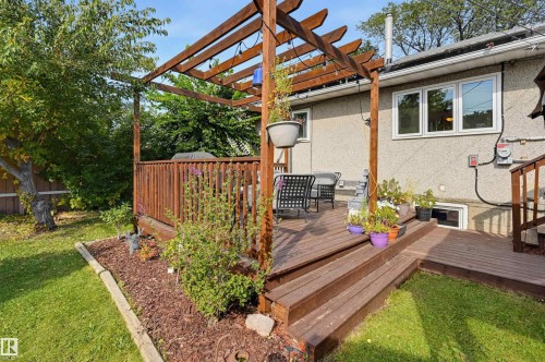 Expansive wood deck with pergola, wood railings, and integrated steps - 13655 122 Avenue Nw, Edmonton, AB 