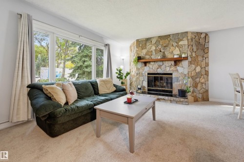 Stone-clad fireplace with a wood mantel - 13655 122 Avenue Nw, Edmonton, AB 