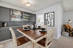 Built-in cabinetry with glass-front display, overhead flush-mount lighting, and an open pass-through window to an additional space - 