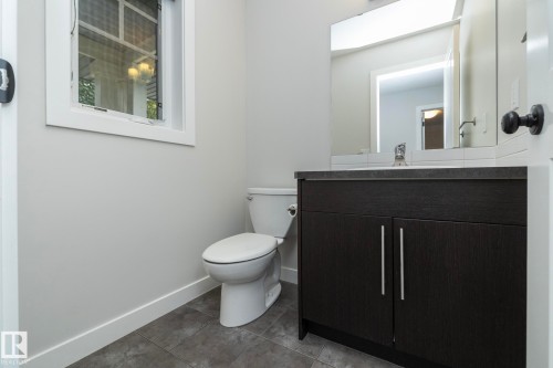 Dark wood-finish vanity with a light countertop, integrated sink, and chrome faucet - 53 Michigan Street, Devon, AB 