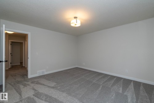 Neutral wall finishes, textured carpeting, and a flush-mount ceiling light fixture - 53 Michigan Street, Devon, AB 