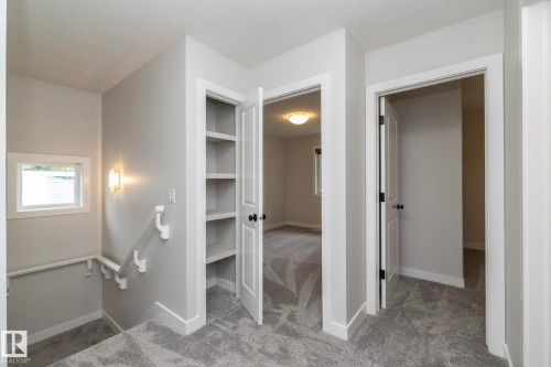 Built-in shelving, two panel doors, wall sconce, and textured carpeting - 53 Michigan Street, Devon, AB 