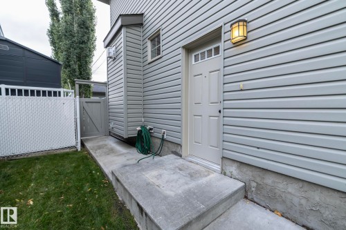 Exterior featuring horizontal siding, a paneled entry door with transom lites, and an exterior wall light fixture - 53 Michigan Street, Devon, AB 