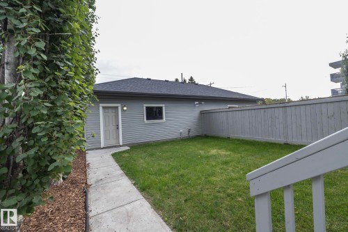 Expansive yard featuring a manicured lawn, concrete pathway, and privacy fencing - 53 Michigan Street, Devon, AB 