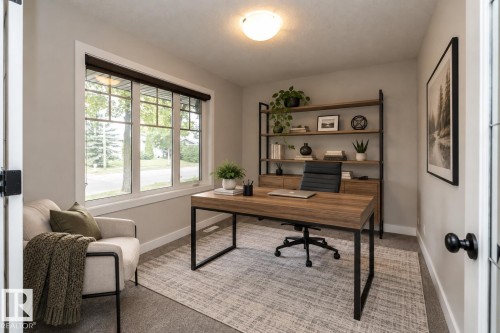 Neutral wall paint, plush carpet flooring, a multi-pane window with white trim, a built-in wood-finish shelving unit, and a flush-mount ceiling light fixture - 53 Michigan Street, Devon, AB 