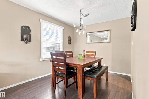 Wood-finish flooring, neutral wall tones, and overhead chandelier - 12 Hughes Road Nw, Edmonton, AB 
