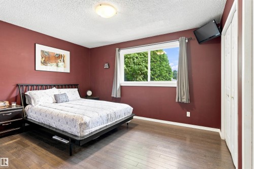 Hardwood-finish flooring, a large window with white trim, and a ceiling-mounted light fixture - 12 Hughes Road Nw, Edmonton, AB 