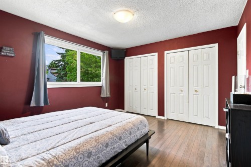 Wood-finish flooring, two sets of bi-fold closet doors, and large picture window - 12 Hughes Road Nw, Edmonton, AB 