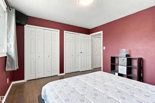 Wood-finish flooring, white bi-fold closet doors, and a ceiling-mounted light fixture - 12 Hughes Road Nw, Edmonton, AB 