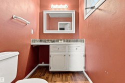 White vanity with dual cabinet storage and drawer hardware, accompanied by a tiled backsplash - 