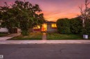 Single-story home featuring a red front door, mature front yard trees, and manicured shrubs - 12 Hughes Road Nw, Edmonton, AB 