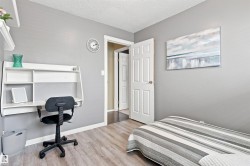 Light gray wall paint, wood-finish flooring, white paneled door, and a built-in wall desk - 