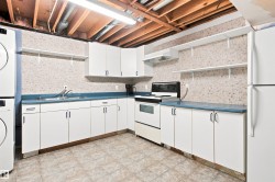 White cabinetry, laminate countertops, tile flooring, exposed ceiling beams, and open shelving - 
