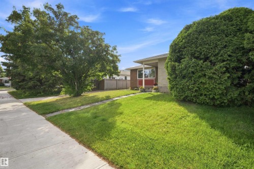 Expansive front lawn with mature trees and a concrete sidewalk - 12 Hughes Road Nw, Edmonton, AB 