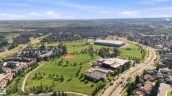 Expansive green spaces, diverse residential buildings, visible roadways, and commercial structures - 