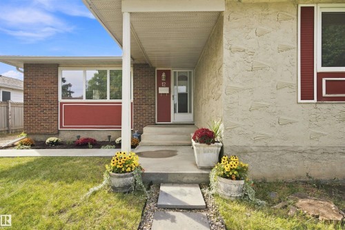 Brick and textured stucco exterior, covered entry, and front porch with concrete steps - 12 Hughes Road Nw, Edmonton, AB 