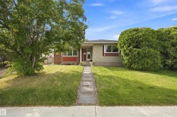 Front exterior with a concrete sidewalk and a stone-paver walkway - 