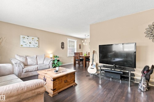 Dark wood-finish flooring, neutral wall paint, and recessed window with blinds - 12 Hughes Road Nw, Edmonton, AB 