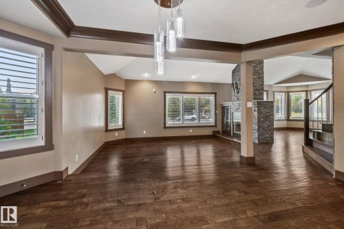 Dark wood-finish flooring, vaulted ceilings, and a decorative stone-clad fireplace - 10 Eldorado Drive, St. Albert, AB 