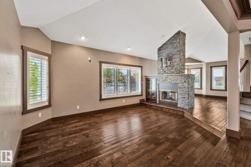 Vaulted ceilings, wood-finish flooring, stone fireplace, built-in cabinetry, and multiple windows with plantation shutters - 10 Eldorado Drive, St. Albert, AB 
