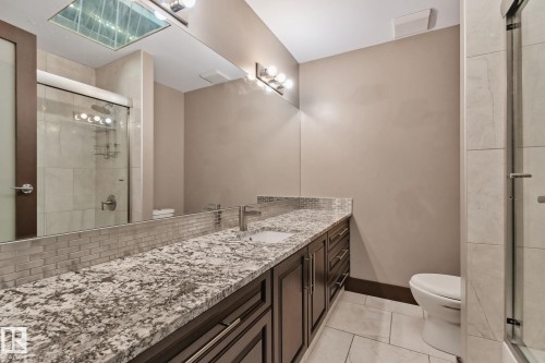 Double vanity with a stone countertop, a tile backsplash, and dark wood cabinetry - 10 Eldorado Drive, St. Albert, AB 