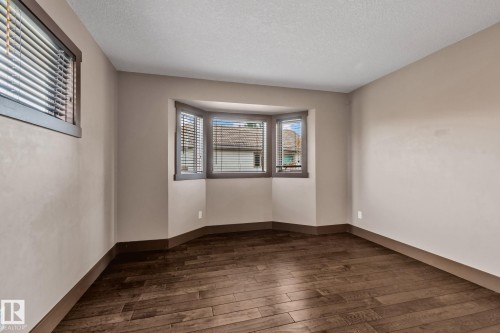Hardwood-finish flooring, neutral wall tones, and a bay window with blinds - 10 Eldorado Drive, St. Albert, AB 
