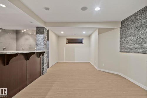 Built-in bar with stone accents, recessed lighting, and wood-finish flooring - 10 Eldorado Drive, St. Albert, AB 