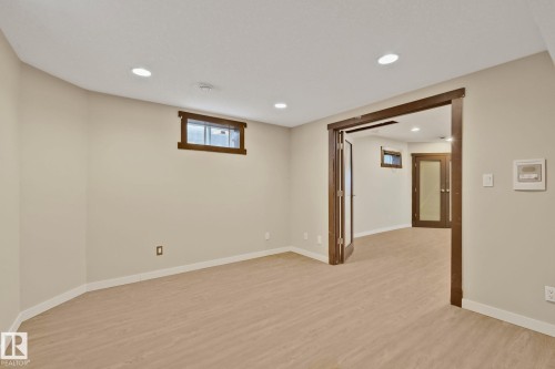 Recessed lighting, wood-finish flooring, wood-framed windows, and a wood-trimmed doorway with glass-paneled double doors - 10 Eldorado Drive, St. Albert, AB 