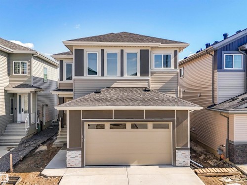 Contemporary exterior featuring mixed material siding, a two-car garage, and multiple upper-level windows - 11 Dalquist Bay, Leduc, AB 