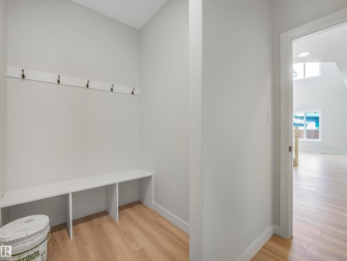 Built-in bench seating with open storage, integrated wall-mounted coat rack, and wood-finish flooring - 11 Dalquist Bay, Leduc, AB 