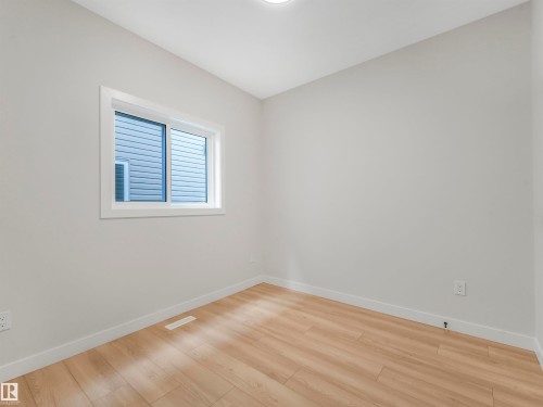 Light wood-finish flooring, white trim, and a window with white casing - 11 Dalquist Bay, Leduc, AB 